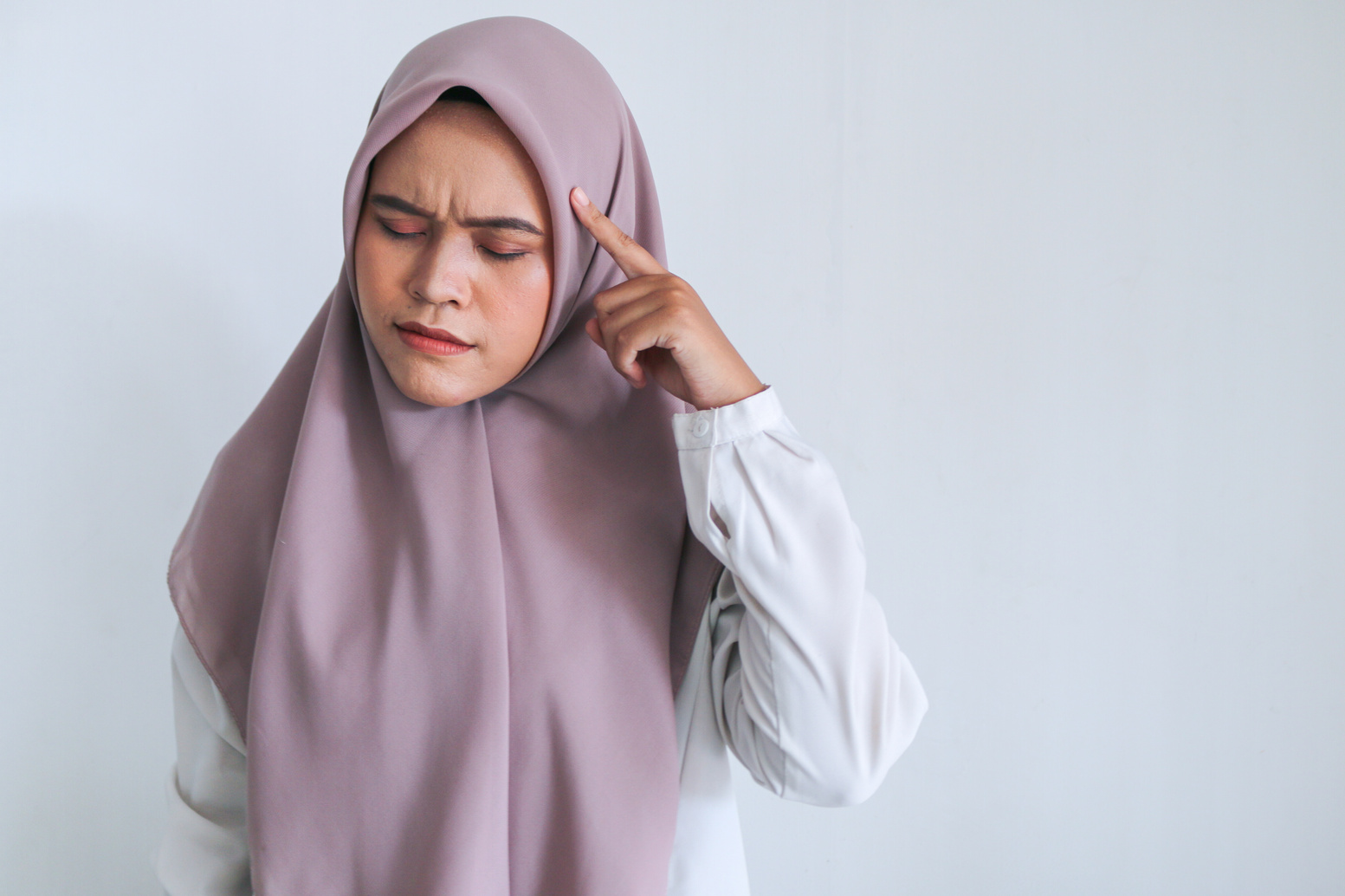 Young Asian Islam woman wearing headscarf is putting a finge